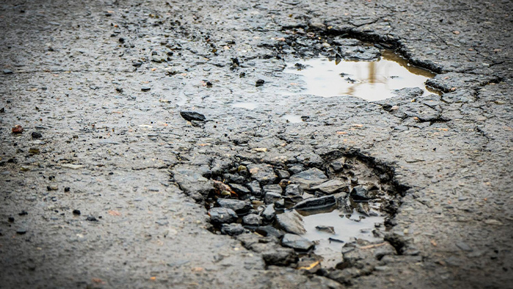 Rozbitá silnice patří Správě železnic
