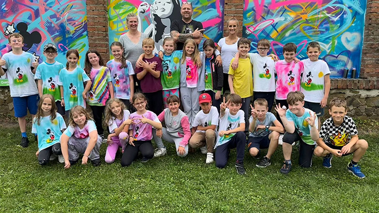 Děti z Bedihoště si hrají u zdi plné srdcí